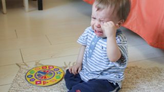 A toddler crying on the floor