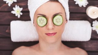 A young woman enjoying spa with her eyes covered with cucumber slices