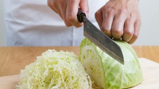 Cabbage being cut with a knife