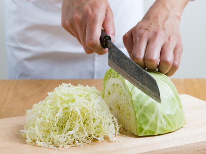 Cabbage being cut with a knife