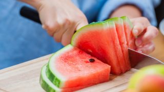 Close up of a person cutting a watermelon