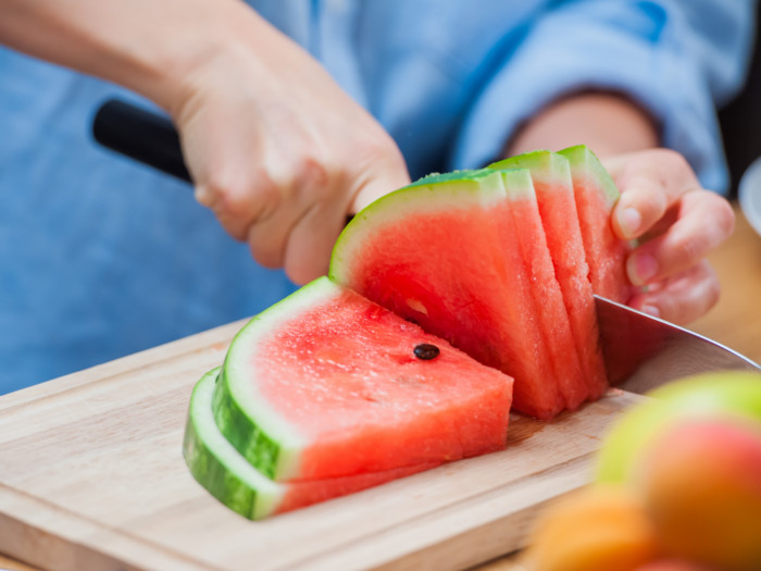 Close up of a person cutting a watermelon