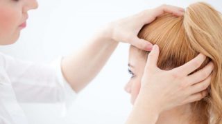 A doctor treating a girl for a cyst on the scalp