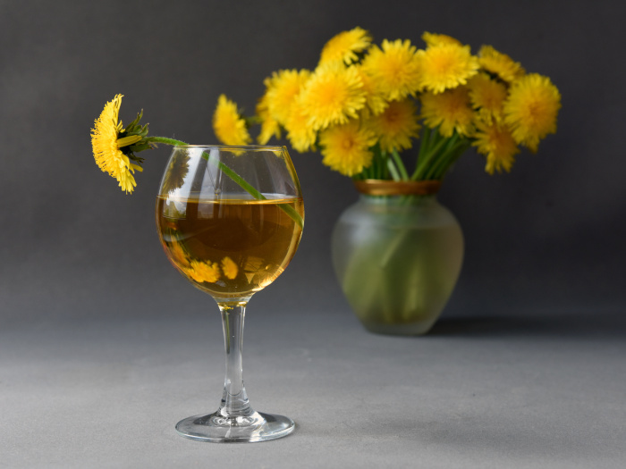 A close up picture of a glass of dandelion wine kept atop a table