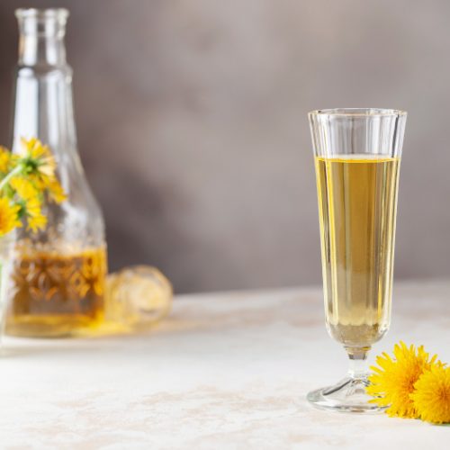 Dandelion homemade wine in a glass and bottle
