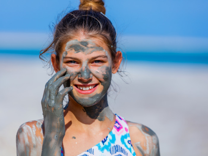 A young girl with dead sea mud pack on her face
