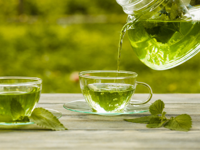 A person pouring tea into a cup