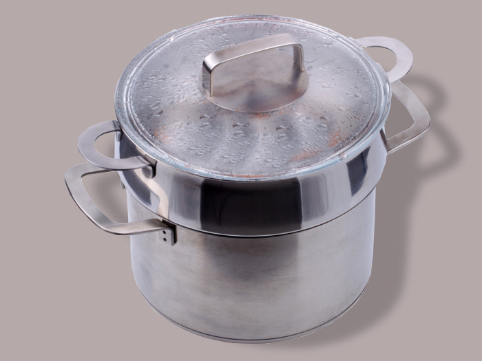 A double boiler on a light lavender-colored background.