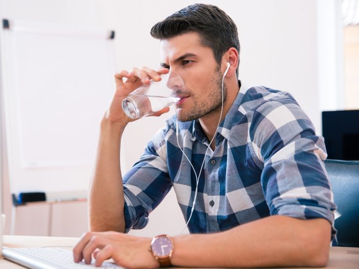 Man with earphones drinking water