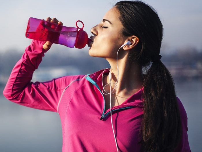 A woman drinking water from a bottle