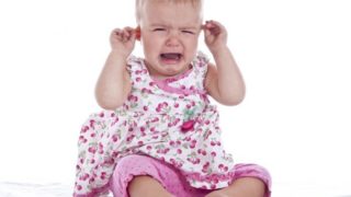 A crying infant girl with an earache