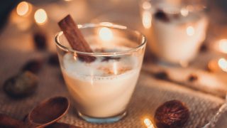 Eggnog in glasses with star anise and cinnamon on wooden table for Christmas and winter holidays