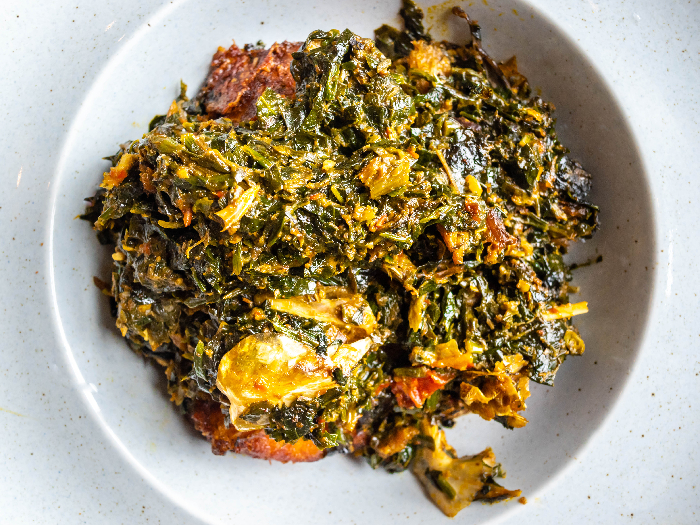 Nigerian food, a vegetable Egusi soup on a white plate