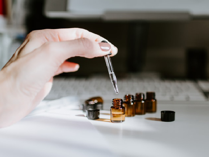 Close up of a woman's hands who is using a dropper from small bottles