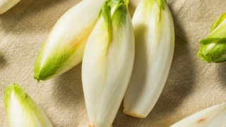 three endives on a brown background