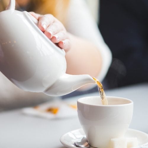 Woman pouring tea into a teacup