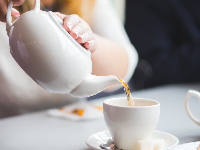 Woman pouring tea into a teacup