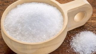 Epsom salt in a rustic wooden bowl against a wood background