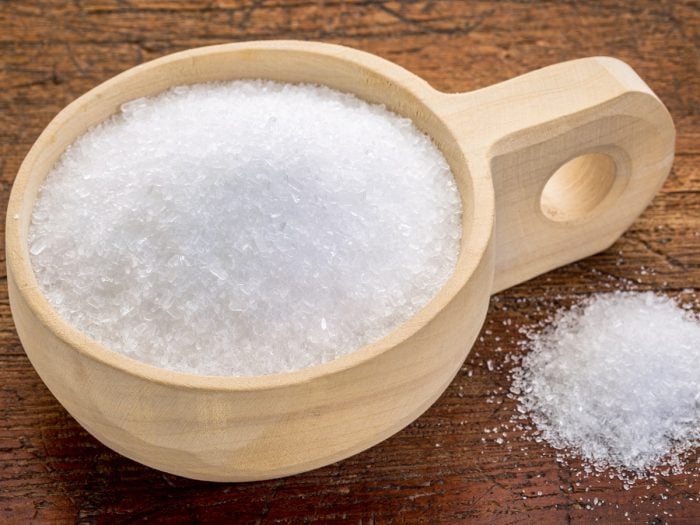 Epsom salt in a rustic wooden bowl against a wood background