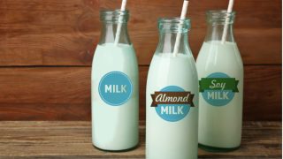 Three milk bottles labeled, milk, almond milk, and soy milk.