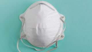 White face mask on a green background.