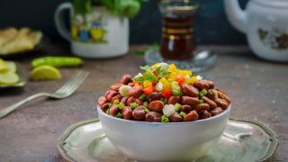Fava bean salad in a white bowl on a platter
