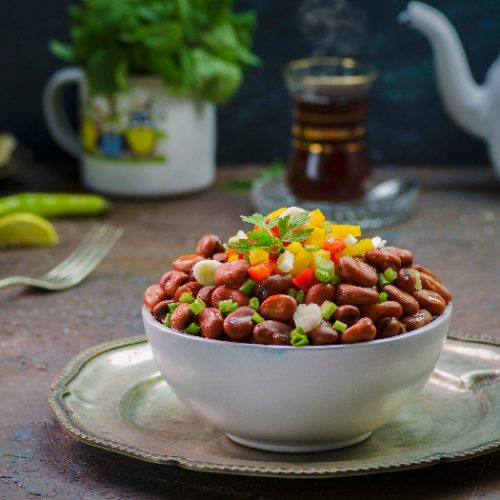 Fava bean salad in a white bowl on a platter