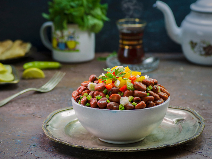 Fava bean salad in a white bowl on a platter