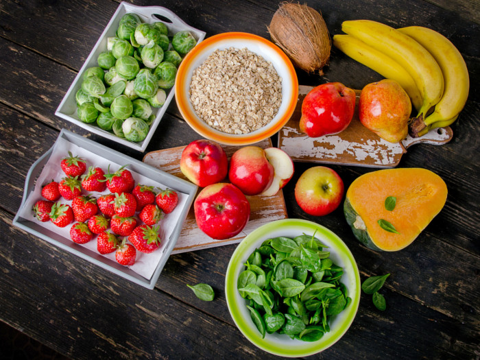 Fiber-rich foods like oats, fruits, vegetables, and papaya on wood