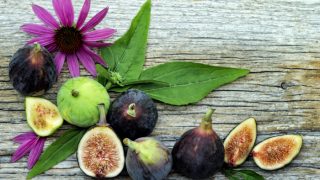 Whole and sliced figs on a wooden table