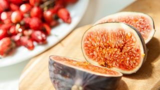 A close up shot of cut figs placed atop a wooden board