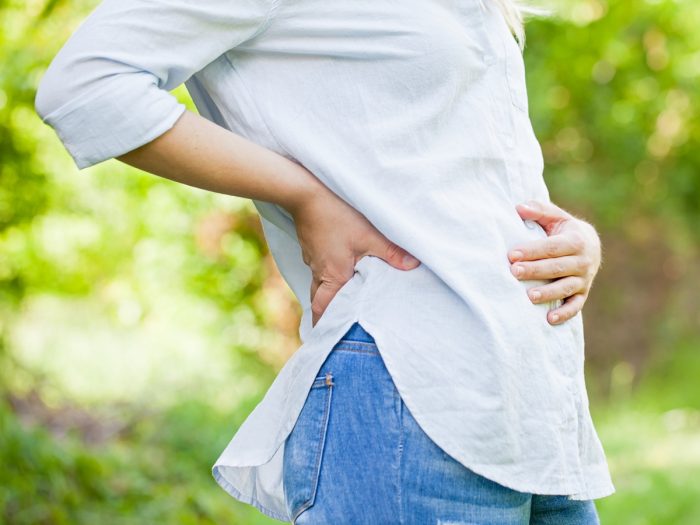 Closeup picture of a woman holding her belly.