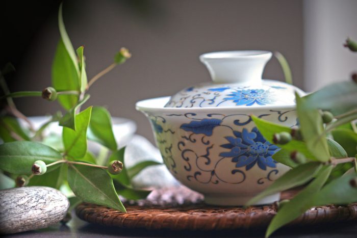 A pot sitting on a mat in between leaves