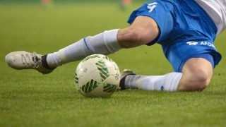 A football player kicking a ball on a field
