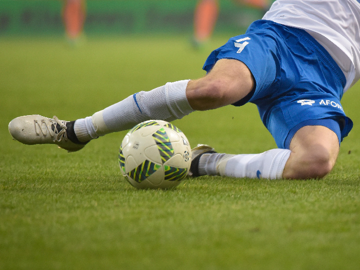 A football player kicking a ball on a field