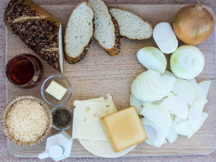 Easy french onion soup ingredients on wood cutting board and wood background, French onion soup ingredients