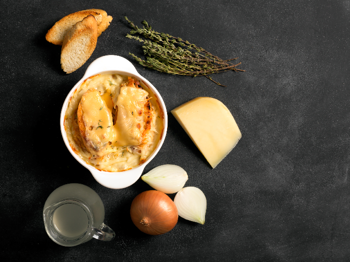 French onion soup on the black background with its ingredients