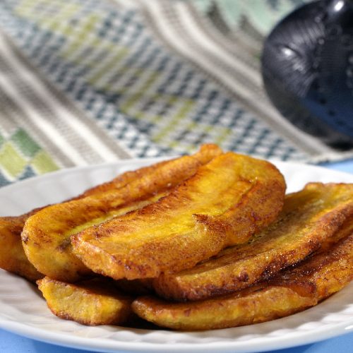 Stack of fried sliced plantain bananas on plate