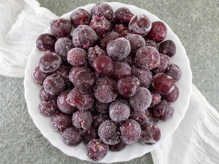 A flat lay picture of frozen black grapes