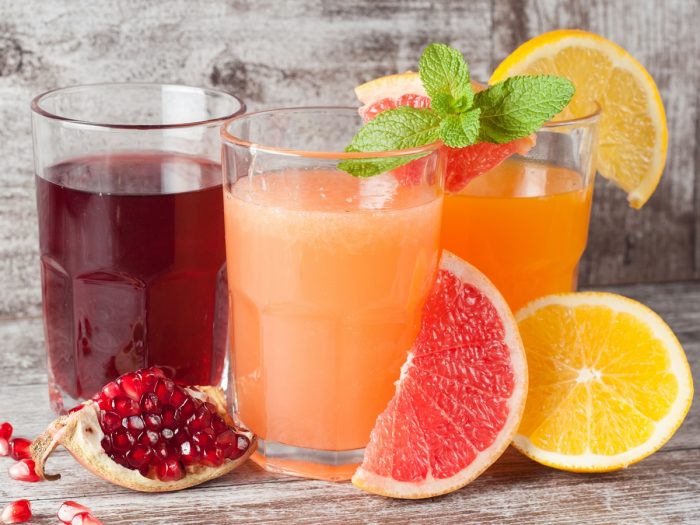 Glasses of freshly made pomegranate, sweet melon, and orange juice