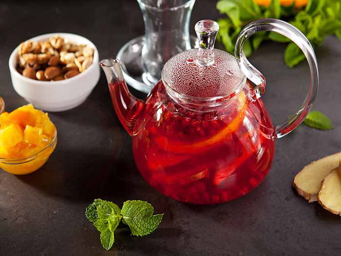 Fruit tea jar surrounded by ingredients