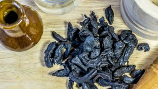 Kokum on a cream wooden table with a vintage brown thin vase