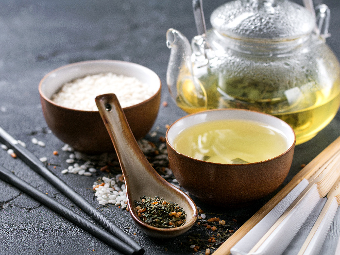 Genmaicha tea with roasted brown rice served in the glass teapot and ceramic bowl