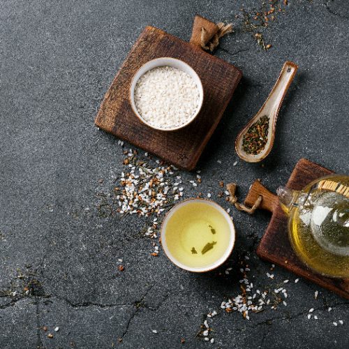 Genmaicha tea in the glass teapot and ceramic bowl and decorated with white rice