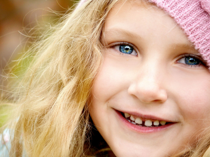 A headshot of a little girl smiling