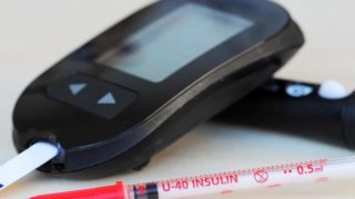 An insulin detector machine next to a syringe