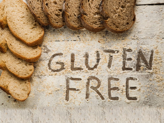 A flat-lay picture of gluten-free bread arranged around the corners of the platform and gluten-free written in the middle