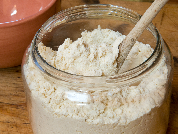 Gluten-free flour mix for baking in an old jar with spoon