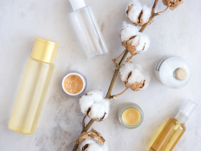 Toner in a bottle, a cotton stalk, and lotions