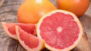 A closeup view of whole and sliced grapefruit